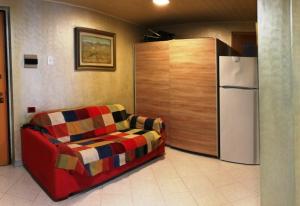 een woonkamer met een bank en een koelkast bij Mira in Alghero
