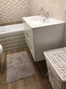 łazienka z umywalką, wanną i toaletą w obiekcie Gdansk Apartament Harmonia Oliwska w Gdańsku +33 zdjęcia