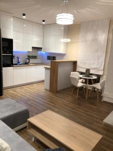 kuchnia i salon ze stołem i krzesłami w obiekcie Gdansk Apartament Harmonia Oliwska w Gdańsku