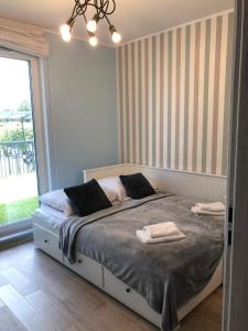 sypialnia z łóżkiem i dwoma ręcznikami na nim w obiekcie Gdansk Apartament Harmonia Oliwska w Gdańsku