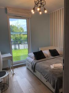 sypialnia z łóżkiem i dużym oknem w obiekcie Gdansk Apartament Harmonia Oliwska w Gdańsku