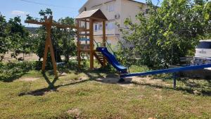 a wooden playground with a wooden cross and a swing at Apartment Lopar 4 in Lopar