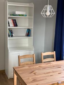 a dining room table with two chairs and a book shelf at Kapitański Hel in Hel