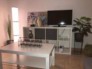 a living room with a white entertainment center with a tv at Villa Las Coquetas "Optical Fiber" in Caleta De Fuste