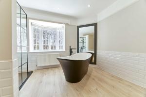 a bathroom with a bath tub and a mirror at Host & Stay - The Old Rectory in Witton Gilbert