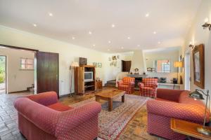 a living room with couches and a table and a kitchen at Quinta das Figueiras - Bordeira - Faro in Bordeira