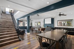 a living room with a table and a staircase at Samesun Hollywood Hotel & Hostel in Los Angeles