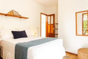 a bedroom with a white bed with a blue blanket at Jeri Pousada in Jericoacoara