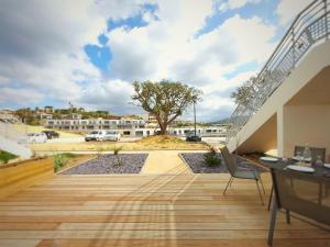 eine Terrasse mit einem Tisch, einem Stuhl und einem Baum in der Unterkunft Appartement CATALINA - Double terrasse - WIFI - Clim - PORTICCIO in Porticcio