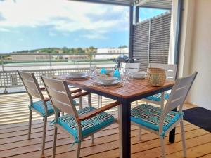 d'une table et de chaises en bois sur un balcon. dans l'établissement Appartement CATALINA - Double terrasse - WIFI - Clim - PORTICCIO, à Porticcio