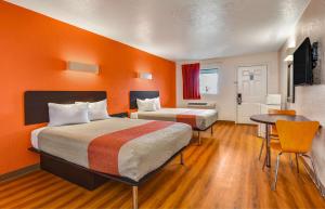 um quarto de hotel com duas camas e uma mesa em Motel 6-Moultrie, GA em Moultrie
