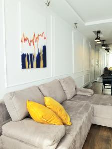 uma sala de estar com um sofá com duas almofadas amarelas em Apartament Modrzewskiego em Grudziądz
