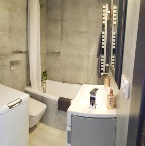 y baño con lavabo, aseo y bañera. en Apartament Modrzewskiego, en Grudziądz