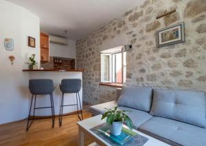 a living room with a blue couch and two stools at City center apartment Roza in Makarska
