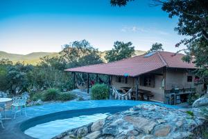 a house with a swimming pool in front of a house at Chácara Morro da Pedra in Cavalcante