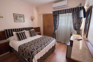 a hotel room with a bed and a flat screen tv at Gran Hotel Continental in Mar del Plata