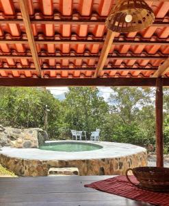 um pátio com uma piscina com cadeiras e uma mesa em Chácara Morro da Pedra em Cavalcante