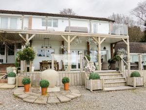 uma casa com um conservatório com vasos de plantas em High Rigg Garden Cottage em How