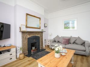 a living room with a couch and a fireplace at Lluest in Beaumaris