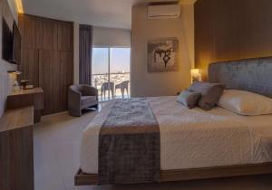 um quarto com uma cama grande e uma varanda em Sara N Hotel & Spa em Zapotlanejo