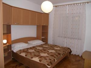 1 dormitorio con 1 cama con dosel y 1 lámpara en Apartments Mirko - 100m from beach, en Ugrinići