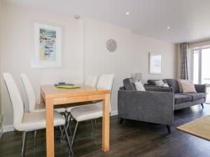 a living room with a table and a couch at Guillemot in Holywell Bay