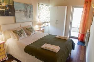 a bedroom with a bed with two towels on it at QUINTA DOS MONTEIROS - 3 Quartos com Piscina in Resende