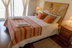 a bedroom with a large bed with a colorful blanket at QUINTA DOS MONTEIROS - 3 Quartos com Piscina in Resende