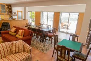 a living room with a table and a dining room at QUINTA DOS MONTEIROS - 3 Quartos com Piscina in Resende