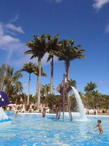 a group of children playing in the water at a resort at Aconchegante Flat no Aldeia das Águas in Barra do Piraí