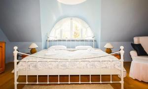 een slaapkamer met een wit bed en een raam bij Skipperhus in Ahrenshoop
