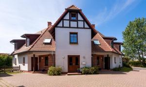 una gran casa blanca con techo de gambrel en Bootsanleger, Landhaus Haven Höövt, en Ahrenshoop