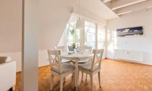 comedor con mesa blanca y sillas en Landhaus Butt 05, en Ahrenshoop