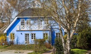 a blue and white house with a tree in front of it at Friederike in Ahrenshoop