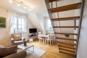 a living room with a staircase leading to a dining room at Strandleben 10 - Louis Douzette in Ahrenshoop