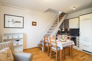 a kitchen and living room with a table and a staircase at Strandleben 11 - Hans Kinder in Ahrenshoop