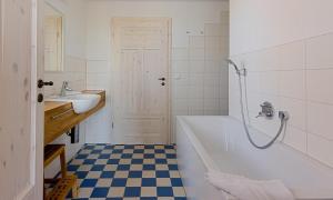 a bathroom with a tub and a sink and a shower at Kapitänshaus - Kajüte in Ahrenshoop +16 photos