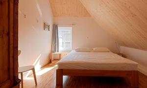 a bedroom with a bed in a attic with a window at Kapitänshaus - Kajüte in Ahrenshoop