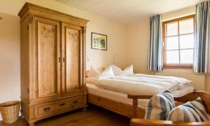 a bedroom with a large bed and a wooden cabinet at Haus am Bodden 03 in Ahrenshoop