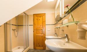 a bathroom with two sinks and a glass shower at Haus am Bodden 03 in Ahrenshoop +20 photos