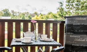 a table with plates and cups and a flower on a balcony at Haus am Bodden 03 in Ahrenshoop