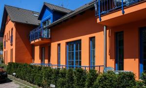an orange building with blue balconies on it at Marikens Deel in Ahrenshoop