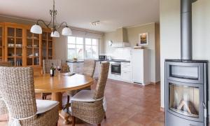 a kitchen with a table and a fireplace in a room at Boddenzauber 01 in Wieck