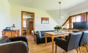 een woonkamer met een tafel en stoelen bij Haus am Bodden 02 in Ahrenshoop