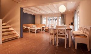 uma cozinha e sala de estar com mesa e cadeiras em Fischerhus em Ahrenshoop