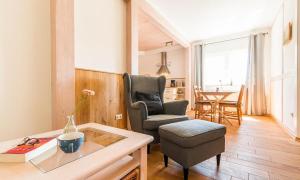 a living room with a chair and a table at Haus Schilfkante - Wohnung 2 in Wieck