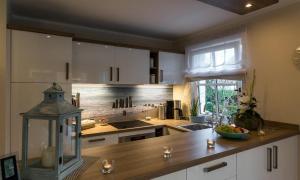 a kitchen with white cabinets and a wooden counter top at Haus Seeschwalbe in Ahrenshoop