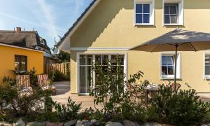 a house with a patio with an umbrella at Haus Seeschwalbe in Ahrenshoop