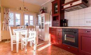a kitchen with red cabinets and a table with chairs at Madlen in Ahrenshoop +11 photos