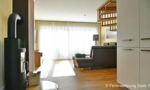 a living room with a couch and a chair and a window at Düne 7 in Dierhagen